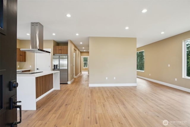 kitchen featuring open floor plan, stainless steel refrigerator with ice dispenser, brown cabinets, modern cabinets, and island range hood