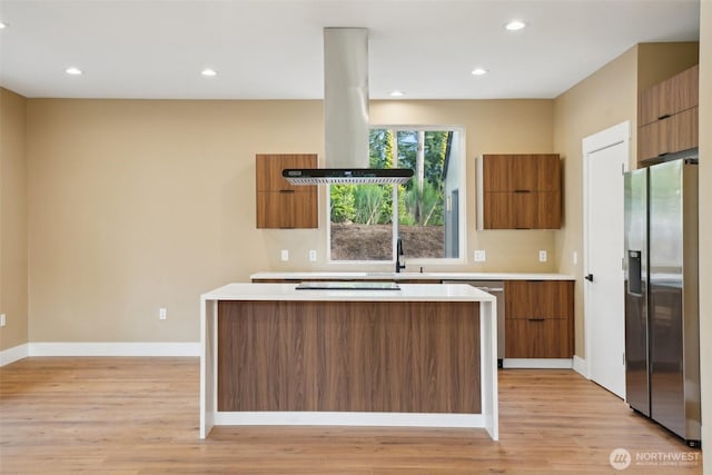 kitchen with stainless steel appliances, brown cabinetry, modern cabinets, and island exhaust hood
