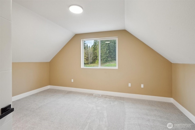 bonus room with baseboards, vaulted ceiling, and carpet floors