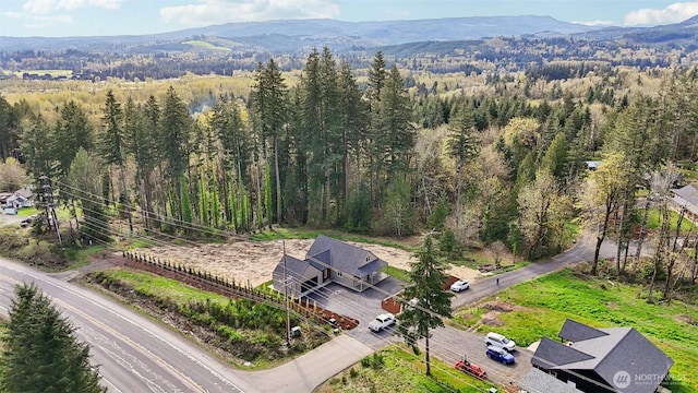 birds eye view of property with a forest view and a mountain view