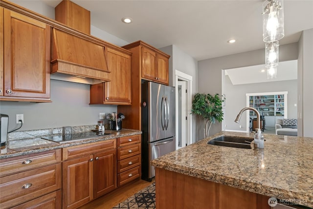 107 Springhill Dr, East Wenatchee, WA 98802 - kitchen featuring black electric stovetop, freestanding refrigerator, brown cabinets, pendant lighting, and a sink