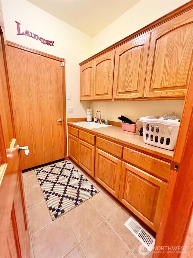 interior space featuring visible vents, a sink, and light tile patterned floors