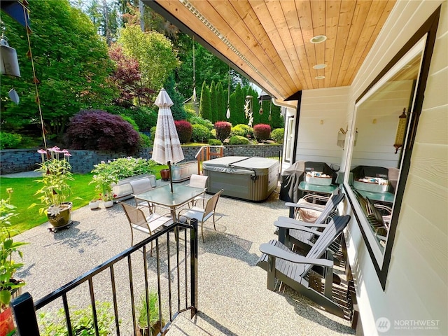 view of patio / terrace with outdoor dining area and a hot tub