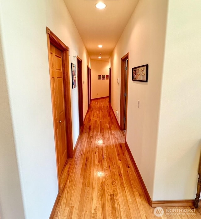 hallway with baseboards, recessed lighting, and light wood-type flooring