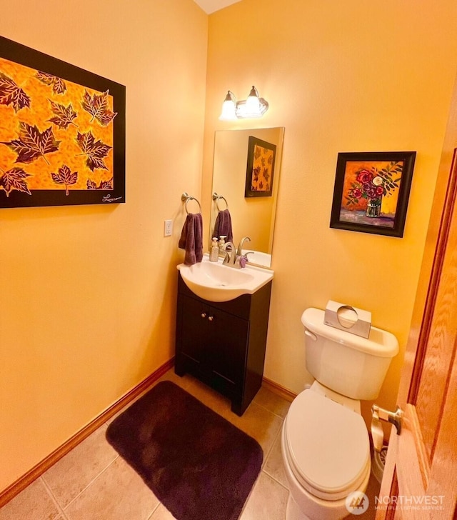 bathroom featuring toilet, vanity, tile patterned floors, and baseboards