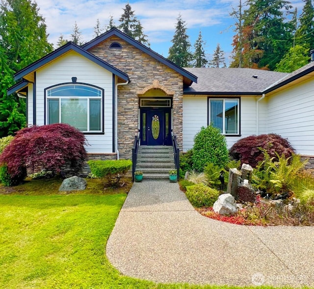 view of front of property featuring a front lawn and stone siding