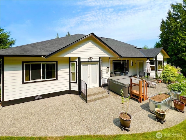 back of property with crawl space, a shingled roof, and a patio