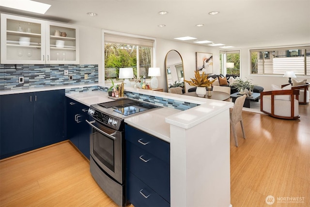 510 Lakeside Ave S Unit 10, Seattle, WA 98144 - kitchen featuring a peninsula, blue cabinets, light countertops, and electric stove