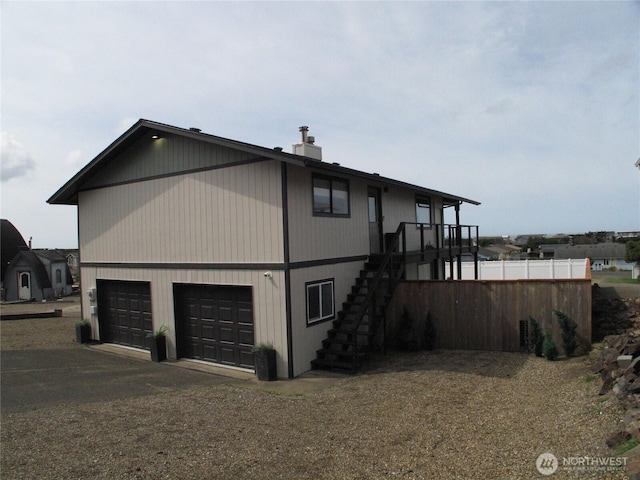 view of side of home featuring a garage, stairway, and driveway