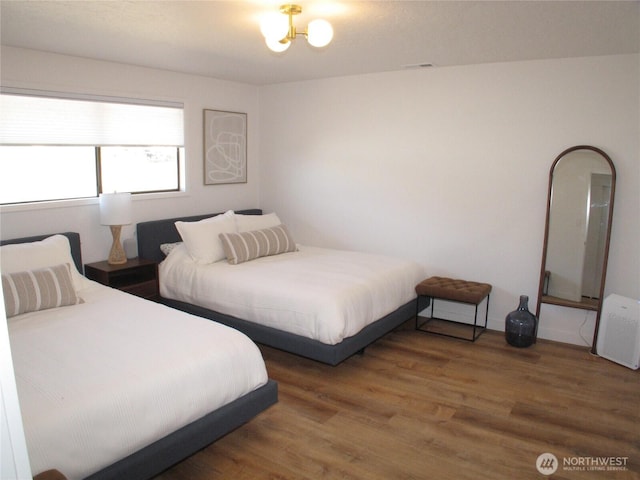 bedroom with visible vents and wood finished floors