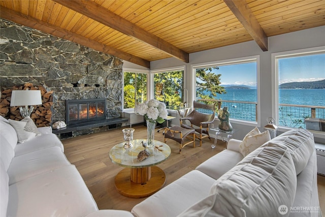 162 Sea Ranch Rd, Lopez Island, WA 98261 - living room featuring lofted ceiling with beams, a water view, wooden ceiling, wood finished floors, and a stone fireplace