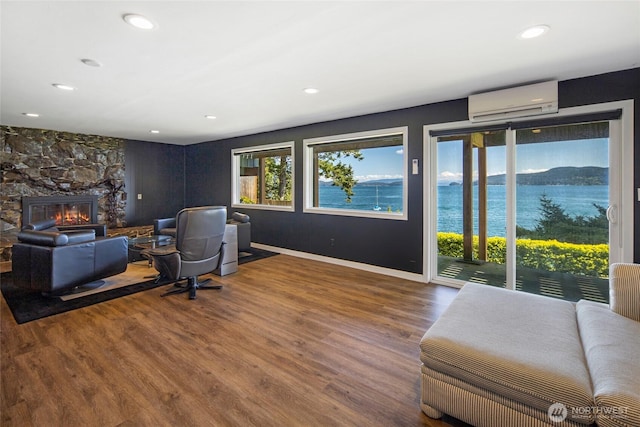 162 Sea Ranch Rd, Lopez Island, WA 98261 - living room with baseboards, recessed lighting, a wall mounted AC, a fireplace, and wood finished floors