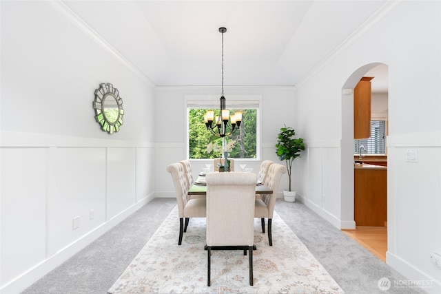 3262 NE Marquette Way, Issaquah, WA 98029 - dining area with light colored carpet, arched walkways, a chandelier, wainscoting, and a decorative wall