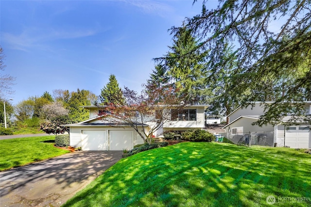 view of front of home featuring concrete driveway, an attached garage, fence, and a front yard