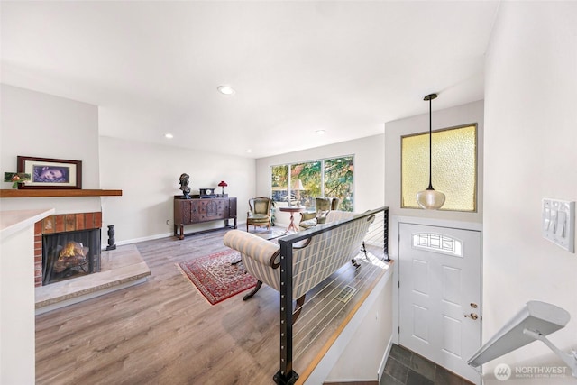 interior space with recessed lighting, baseboards, wood finished floors, and a fireplace