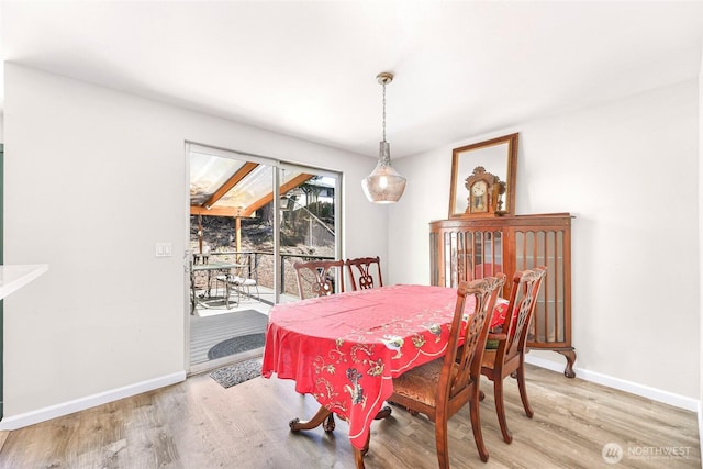 dining space featuring baseboards and wood finished floors