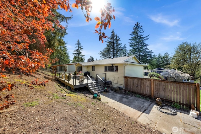 back of house with fence and a deck