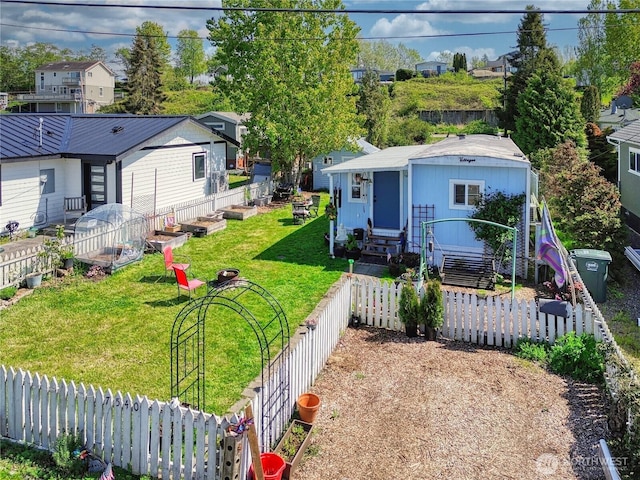 bungalow-style house with a fenced backyard, entry steps, a front lawn, and a residential view