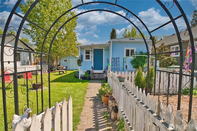 view of front facade with a front yard, fence private yard, an outdoor structure, and entry steps