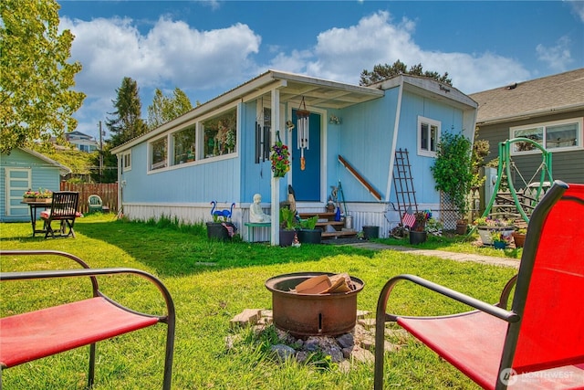 back of house with fence, a yard, and entry steps