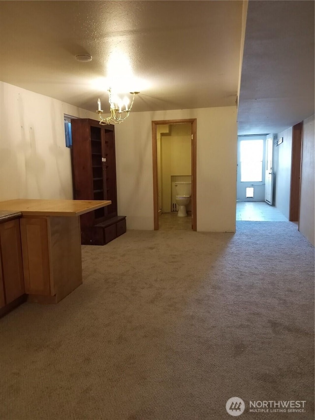 interior space with light colored carpet and an inviting chandelier