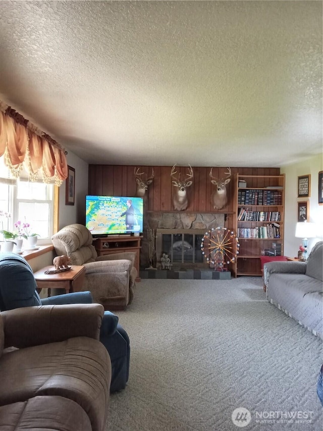 carpeted living area featuring a textured ceiling and a fireplace