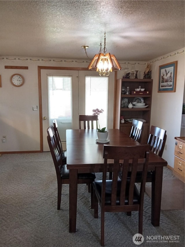 dining area with baseboards, a textured ceiling, a notable chandelier, and light carpet