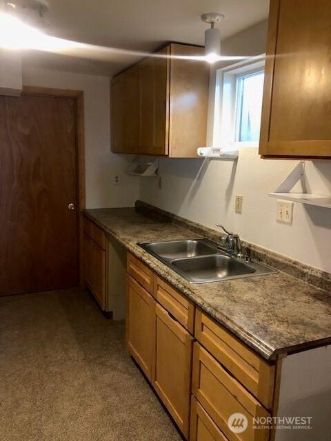 20868 SE Rd 2, Warden, WA 98857 - kitchen with light colored carpet and brown cabinetry