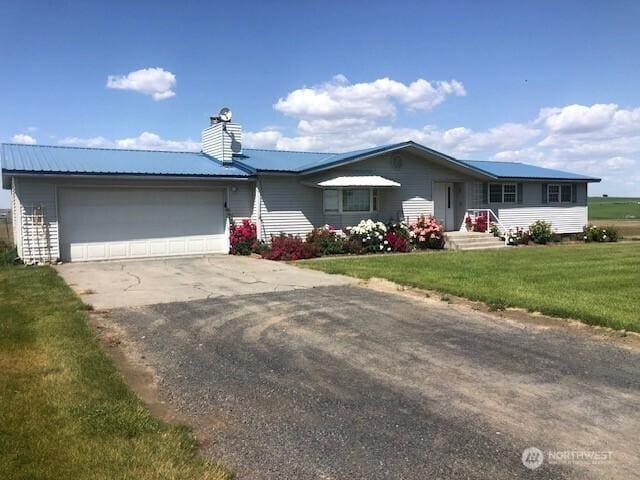 20868 SE Rd 2, Warden, WA 98857 - single story home featuring an attached garage, driveway, a front yard, a metal roof, and a chimney