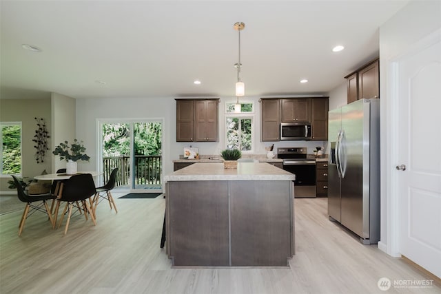 18142 NE Diamond Rd, Poulsbo, WA 98370 - kitchen featuring appliances with stainless steel finishes, light countertops, dark brown cabinets, and a wealth of natural light