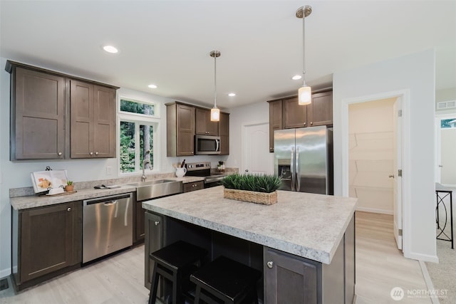 18142 NE Diamond Rd, Poulsbo, WA 98370 - kitchen featuring a center island, a sink, light countertops, dark brown cabinetry, and stainless steel appliances