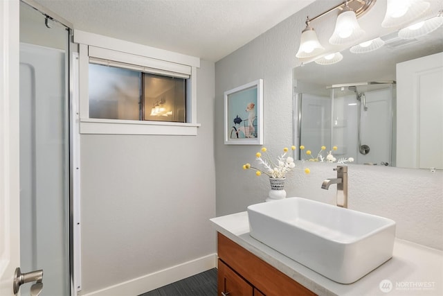 11634 100th Ave NE Unit 323, Kirkland, WA 98034 - full bathroom with a shower stall, vanity, a textured wall, and baseboards