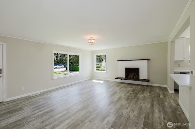 3335 Trenton Ave NE, Bremerton, WA 98310 - unfurnished living room with wood finished floors, baseboards, a brick fireplace, and crown molding
