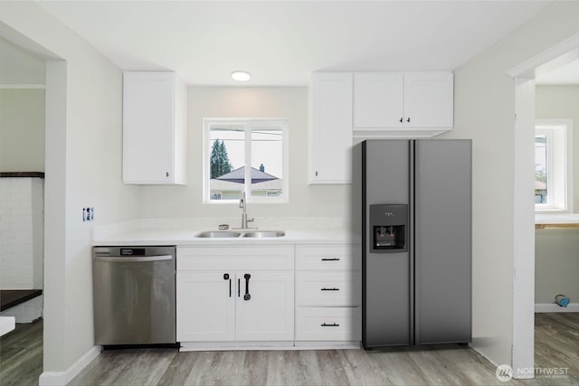 3335 Trenton Ave NE, Bremerton, WA 98310 - kitchen featuring stainless steel appliances, a sink, light wood-type flooring, and white cabinetry