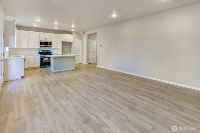 18218 37th Ave E, Tacoma, WA 98446 - kitchen featuring open floor plan, light wood-type flooring, light countertops, and appliances with stainless steel finishes