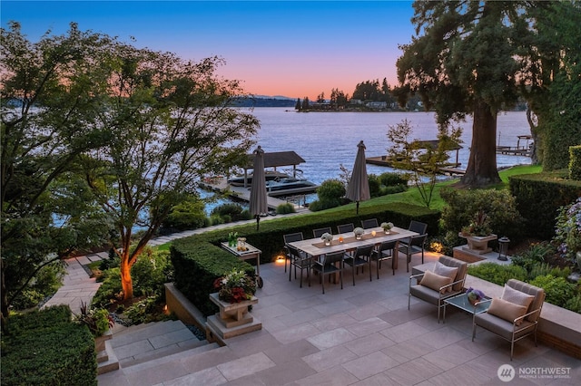 view of patio / terrace with outdoor dining space, a dock, and a water view