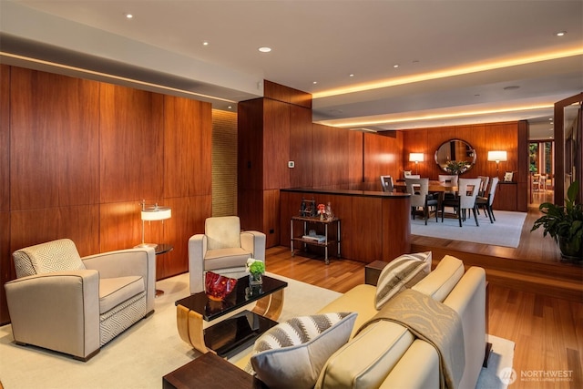 living room featuring wood finished floors, wooden walls, and recessed lighting