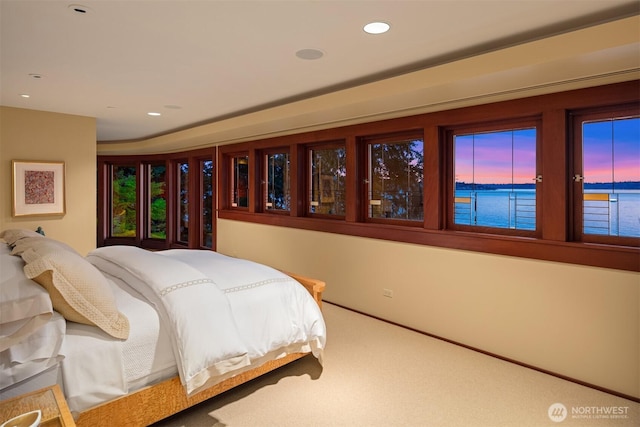 bedroom with a water view, recessed lighting, and carpet