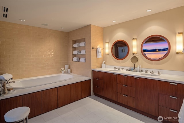 full bath with a sink, a bath, and double vanity