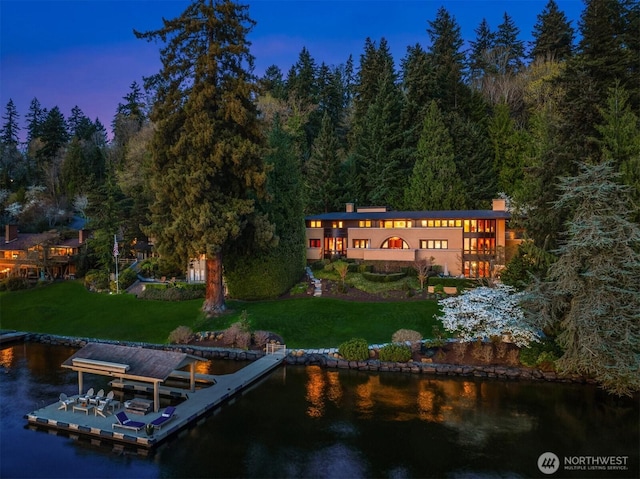 exterior space featuring a water view, a view of trees, and a yard