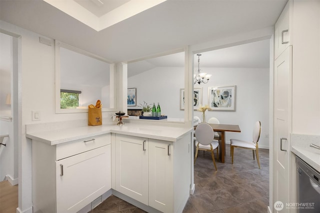 kitchen with stainless steel dishwasher, light countertops, and white cabinetry