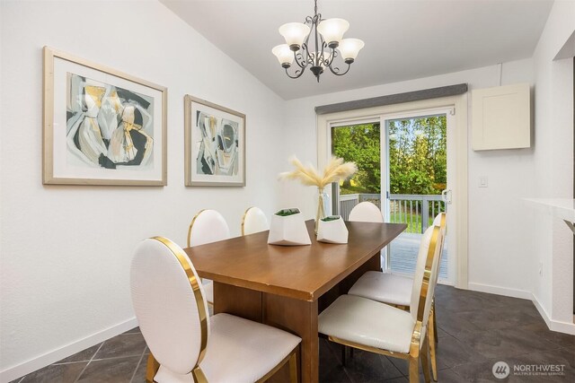 dining area with a chandelier, vaulted ceiling, and baseboards