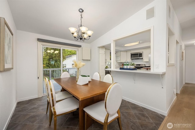 dining area with a chandelier, lofted ceiling, and baseboards