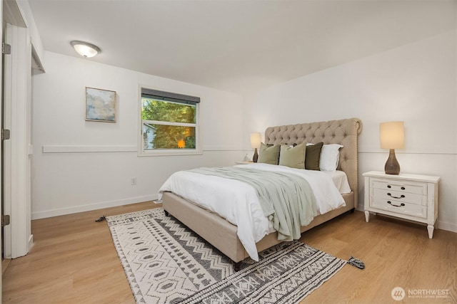 bedroom with light wood finished floors and baseboards