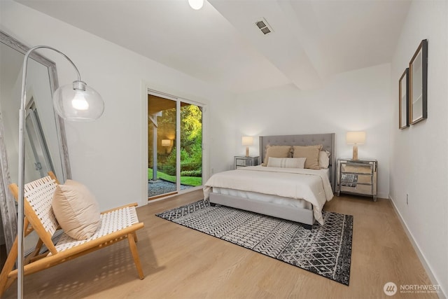 bedroom featuring access to exterior, wood finished floors, and baseboards