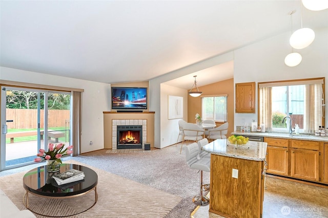 21850 SE 271st Pl, Maple Valley, WA 98038 - kitchen featuring a wealth of natural light, a tile fireplace, light carpet, and light stone countertops
