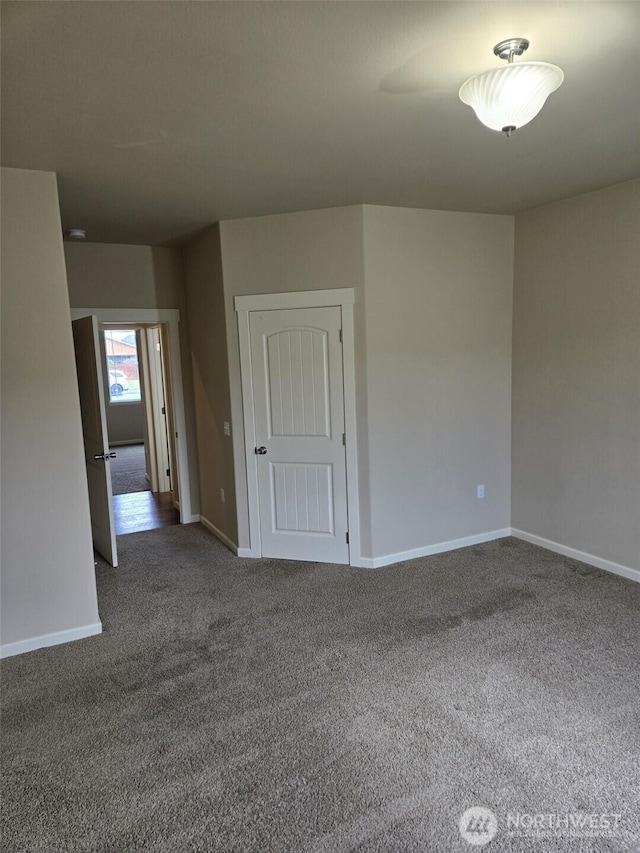 spare room featuring baseboards and carpet