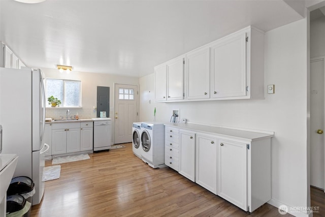 14043 Burke Ave N, Seattle, WA 98133 - laundry room with washer and dryer, light wood finished floors, and a sink