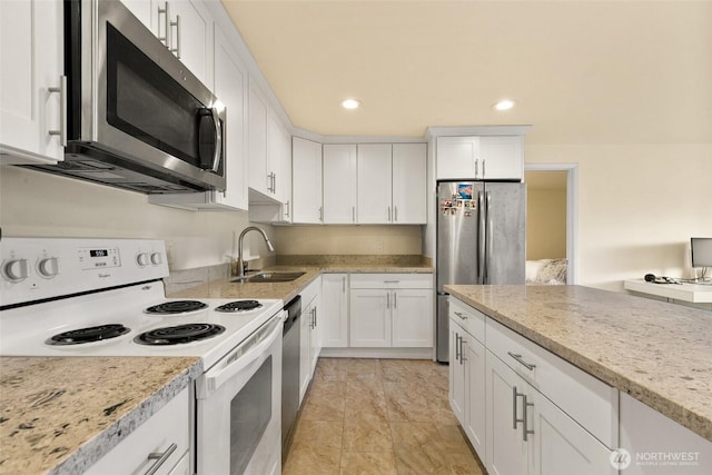 kitchen with light stone countertops, a sink, stainless steel appliances, recessed lighting, and white cabinetry