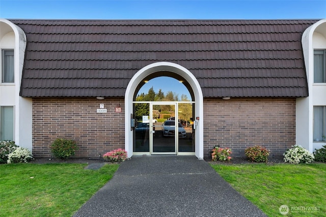 entrance to property with a tiled roof and brick siding